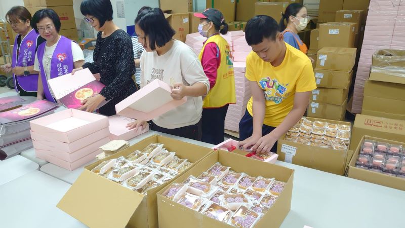 《圖說》大小志工幫忙月餅裝盒。〈社會局提供〉